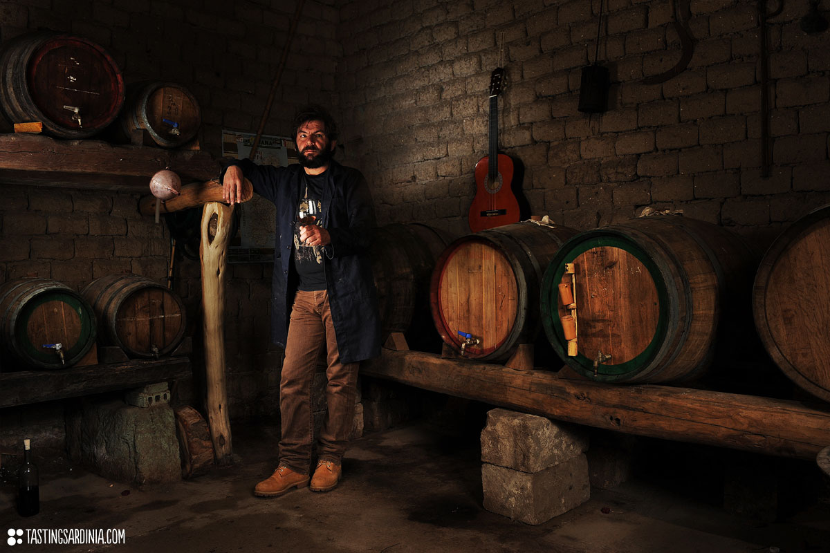 a vernaccia wine producer sipping some wine in his own unfired mud-bricks cellar