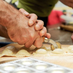 detaching ravioli wiht a pasta cutter during home-made cooking lesson