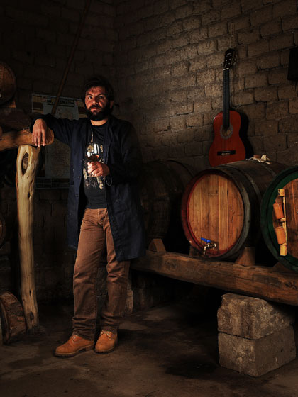 a vernaccia wine producer sipping some wine in his own unfired mud-bricks cellar
